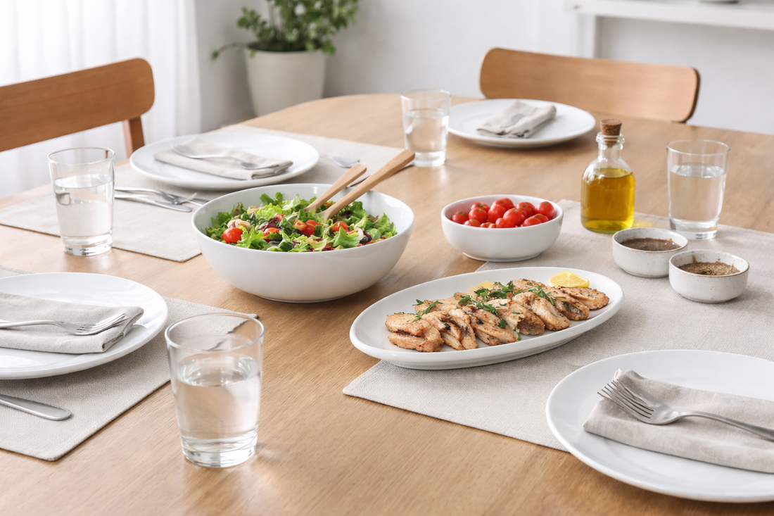 Simple dining table setup with serving bowls, plates, glasses, and shared items arranged for an easy everyday meal